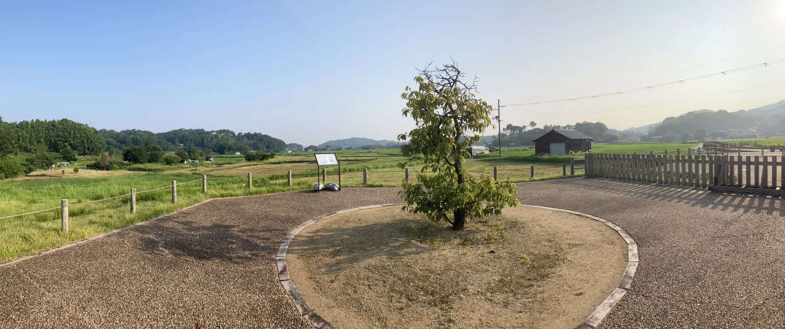 飛鳥京跡苑池周辺の広場と案内板を遠望する風景
