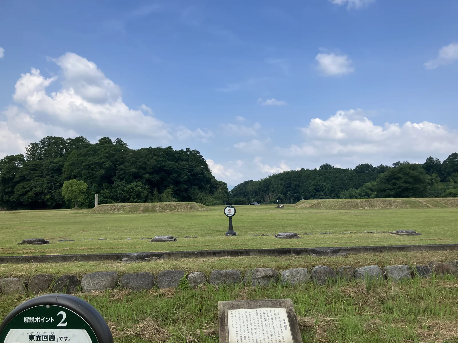 山田寺跡の全景。芝生の広場に礎石が点在し、奥に飛鳥の山並みが見える